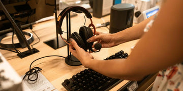 Sklep ze sprzętem elektronicznym. Na pierwszym planie czarne słuchawki przewodowe.