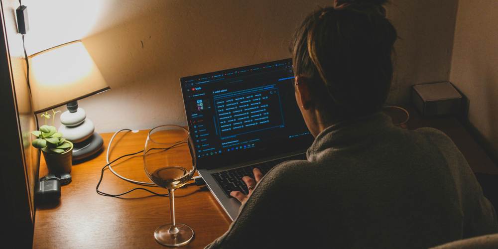 Kobieta pracująca na laptopie w trybie ciemnym.